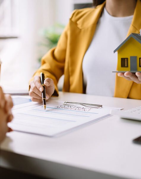 Real estate broker agent presenting and consult to customer to decision making sign insurance form agreement, home model, concerning mortgage loan offer in office
